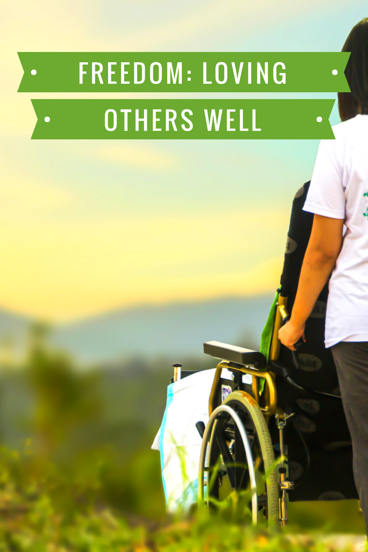 Truth - Freedom: Loving others well. Image - individual pushing someone in a wheelchair